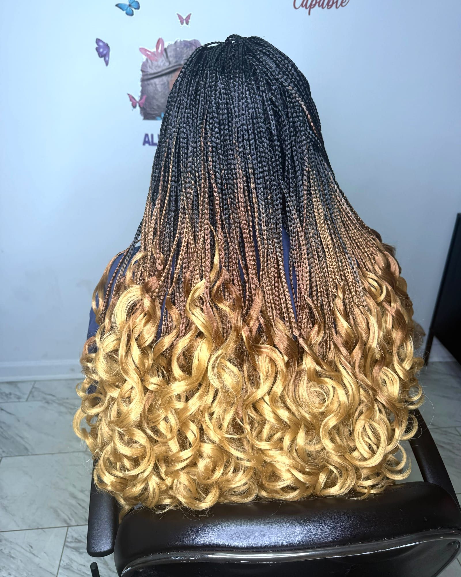 Black-to-blonde ombré braids with bouncy curly ends, styled at Braids With Joy