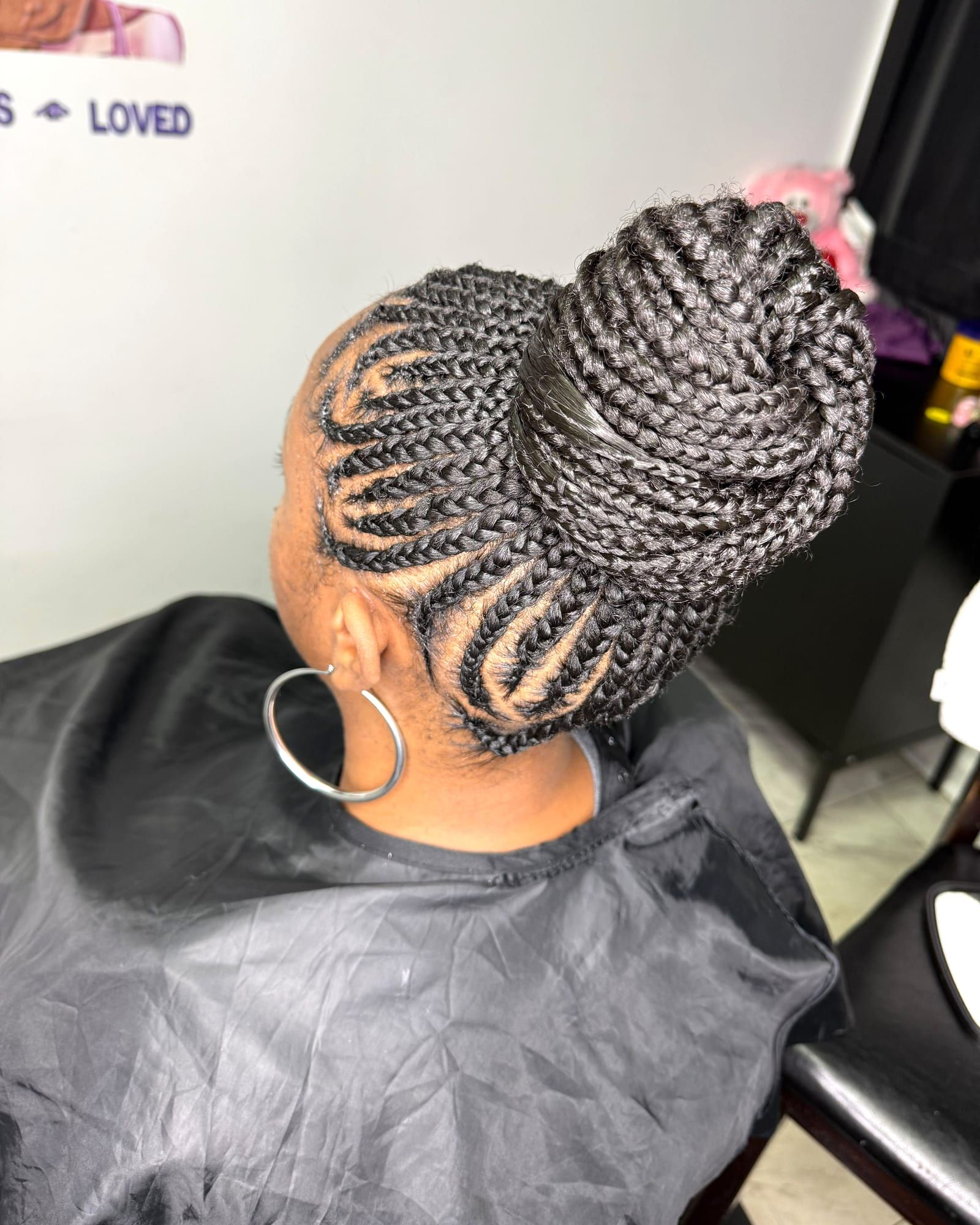 Cornrows swept into a braided top bun